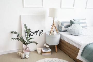 Bedside table with lamp in interior of stylish room