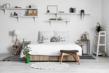 Interior of modern bedroom with tables and houseplants