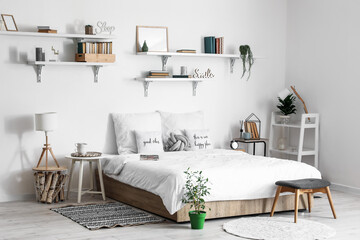 Interior of modern bedroom with tables and houseplants
