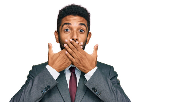 Young african american man wearing business clothes shocked covering mouth with hands for mistake. secret concept.