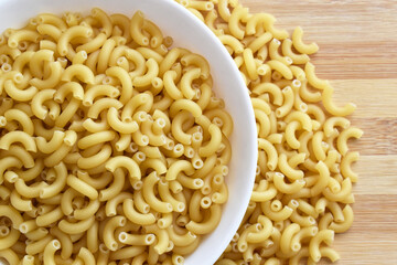 Uncooked raw macaroni on a chopping board. 