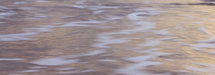 Blurred abstract natural background of sea water with waves and foam. Motion blur. Nature. Banner.	