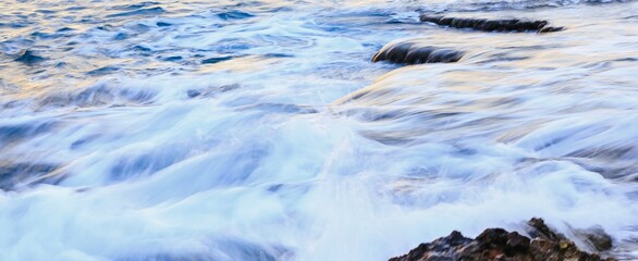 Blurred abstract natural background of sea water with waves and foam. Motion blur. Nature. Banner.	