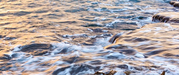 Blurred abstract natural background of sea water with waves and foam. Motion blur. Nature. Banner.	