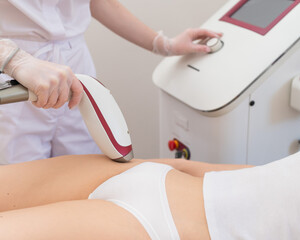 A woman in a professional beauty salon removes unwanted vegetation in the bikini area using laser...