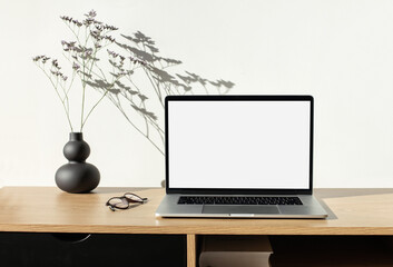 Laptop computer with empty blank mockup screen over white modern living room design. Work place,...