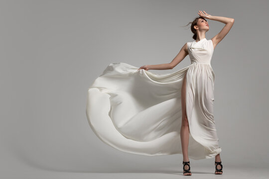 Fashion woman portrait in white long flying airy dress
