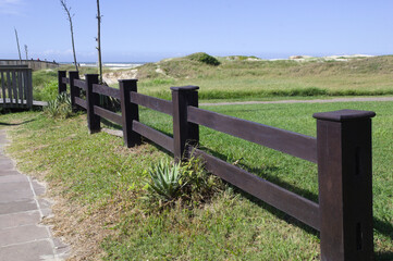 Wooden fence with grass in the background and blue sky