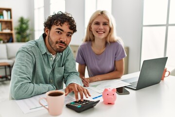 Young couple controlling family economy at home.