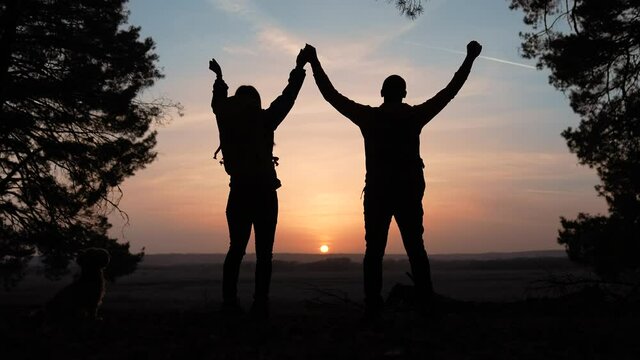 teamwork. business a journey concept win. happy family team tourists man and woman sunset silhouette hands up teamwork hands victory success group business. slow motion video. tourism husband top