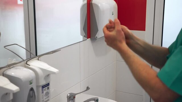 The doctor in a special form and in a mask prepares for operation and carefully washes hands between fingers and palms up to elbows with a soap solution.