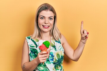 Beautiful caucasian woman eating ice cream smiling with an idea or question pointing finger with happy face, number one