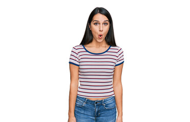 Young hispanic girl wearing casual striped t shirt afraid and shocked with surprise expression, fear and excited face.