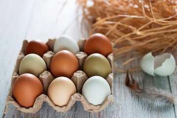 Organic eggs in a paper box on blue old wooden backround.