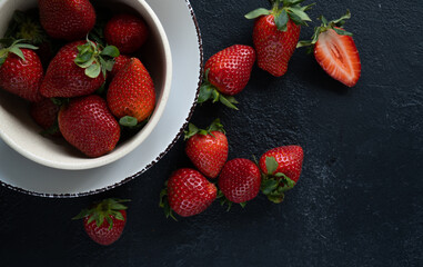 Fresh strawberries in a bowl on a dark background