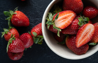 Fresh strawberries in a bowl on a dark background
