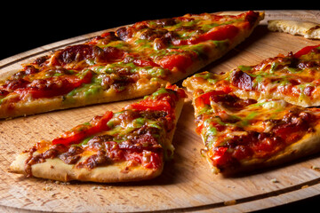 Hot pizza on wooden plate cut in slices. Pizza is partially eaten