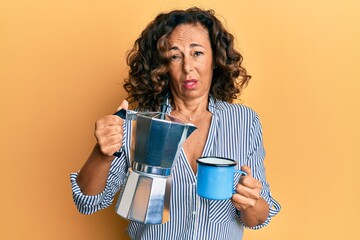 Middle age hispanic woman drinking italian coffee clueless and confused expression. doubt concept.