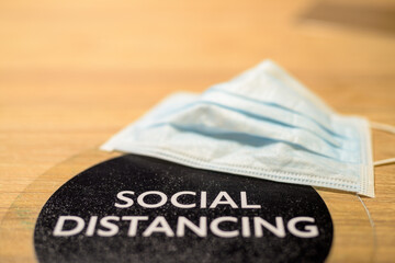 Social distancing text and face mask on table at restaurant