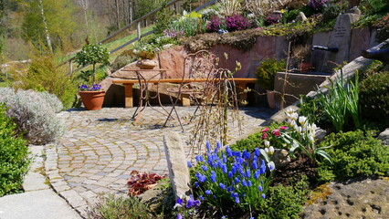 Gartenterrasse mit Tisch, Stuhl, Brunnen und Pflanzen