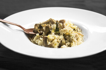 Rissoto de alcachofas y setas plato blanco redondo hondo