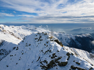 Fototapeta na wymiar snowy peak of the mountain with cross in winter. alps