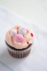 Easter chocolate cupcake with caramel filling and decoration of small Easter eggs from marzipan. Selective focus