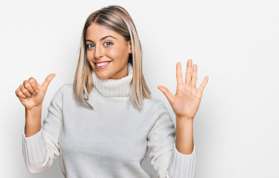 Beautiful blonde woman wearing casual turtleneck sweater showing and pointing up with fingers number six while smiling confident and happy.