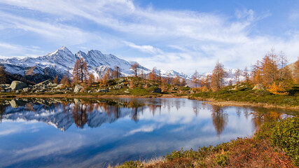 Colorful autumn view of small mountain lake with water reflection. italian alps