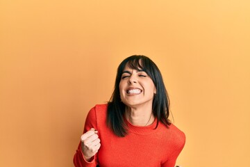 Young hispanic woman wearing casual clothes excited for success with arms raised and eyes closed celebrating victory smiling. winner concept.