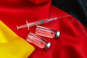 Vaccine vials with syringe on german flag. Vaccination in Germany.