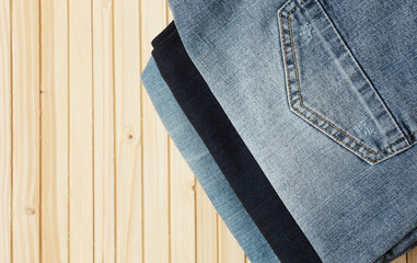 Blue jeans on a wooden background, texture of denim. Top view.