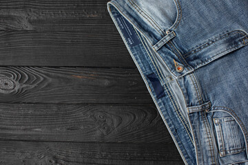 Blue jeans on a wooden background, texture of denim. Top view.