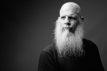 Mature bald man with long white beard in black and white
