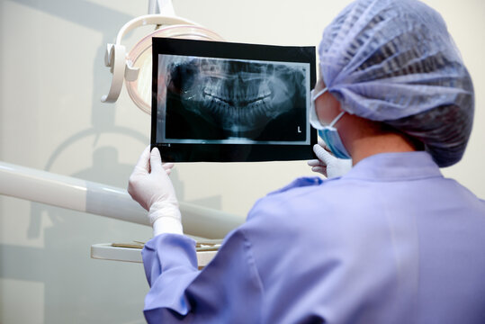 Dentist woman holding to show orthodontist x-ray picture in dentist's office