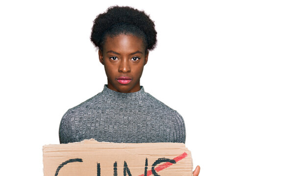 Young african american girl holding no guns warning banner thinking attitude and sober expression looking self confident