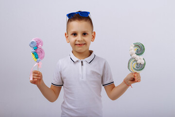 a boy in sunglasses on a white background holds a figure eight candy. Women's day, congratulations....