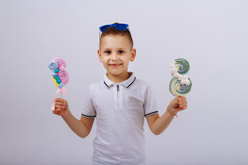 a boy in sunglasses on a white background holds a figure eight candy. Women's day, congratulations....
