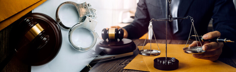 justice and law concept.Male judge in a courtroom on wooden table and Counselor or Male lawyer working in office. Legal law, advice and justice concept.