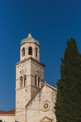 Fototapeta na wymiar Clock tower of Church of St. Nicolas in the village of Cavtat, Croatia