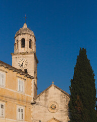 Fototapeta na wymiar Clock tower of Church of St. Nicolas in the village of Cavtat, Croatia