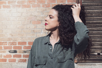 Portrait of curly hair young woman with urban style, latin style, arabic style