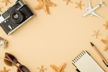 Fototapeta na wymiar Top view photo of camera sunglasses plane model notebook pen seashell and starfishes on isolated beige background with copyspace in the middle