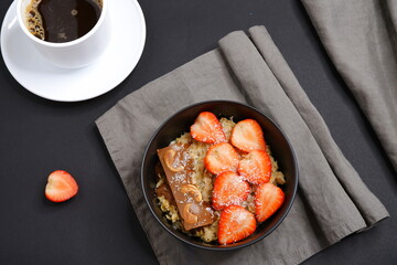 Oatmeal with strawberries and coffee. Cooking. Food.
