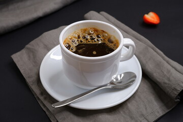 Black coffee on a black background. Delicious drink.