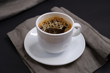 Black coffee on a black background. Delicious drink.