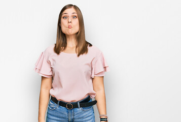 Obraz premium Beautiful caucasian woman wearing casual clothes making fish face with lips, crazy and comical gesture. funny expression.