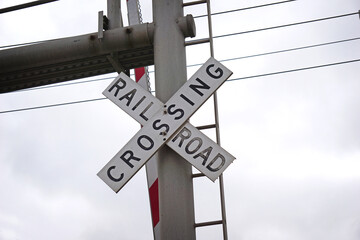 Railroad crossing sign on cloudy day