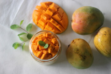 Vanilla custard topped with fresh cut mangoes served in a jar.