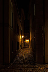 small street at night in old Prague in the historical center with old lamps